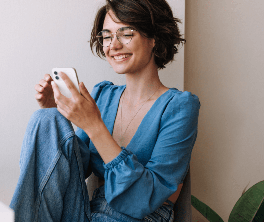 Smiling female using mobile device for online communication